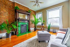 a living room with a brick wall and a fireplace at Jungle House Luxury Stays - Columbus Downtown Short North in Columbus