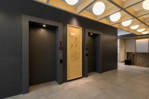 een gang met zwarte muren en een gele deur bij Richmond Hotel Asakusa in Tokyo