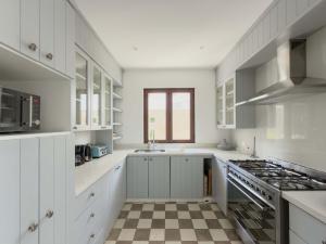 Casapueblo Rent Cachagua CP 34 في Cachagua: مطبخ بخزائن بيضاء وأرضية مربعة