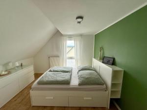 a bedroom with a bed and a green wall at Haus am Tor zur Eifel in Mechernich