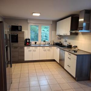 een keuken met witte kasten en een groot raam bij Haus am Tor zur Eifel in Mechernich