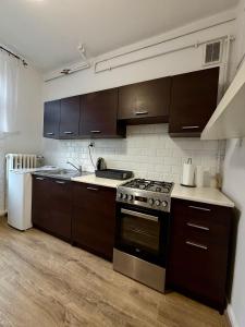 a kitchen with brown cabinets and a stove at Rynek Ratusz in Wrocław +11 photos