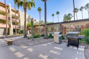 een barbecue en een grill in een binnenplaats met palmbomen bij Patio and Pool Access Walkable Old Town Condo! in Scottsdale
