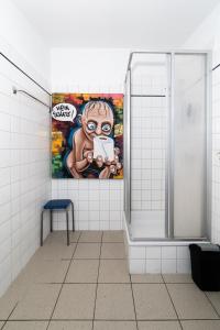 a bathroom with a shower with a painting of a monkey at Pension zur Schleuse Kleinmachnow in Kleinmachnow