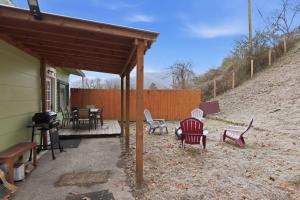 een patio met stoelen, een tafel en een hek bij Cozy Matewan Trail Stay home in Delbarton