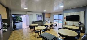 un grupo de mesas y sillas en una habitación en POUSADA CITRINO, en Ametista do Sul