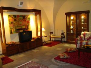 - un salon avec une télévision et un canapé dans l'établissement Appartamento Antica Acropoli, à Centuripe