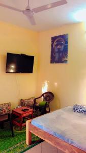 ein Schlafzimmer mit Bett und Flachbildfernseher in der Unterkunft Swahili BNB Homes in Kilifi