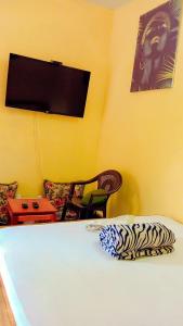 ein Schlafzimmer mit einem Bett und einem Fernseher an der Wand in der Unterkunft Swahili BNB Homes in Kilifi + 2 Fotos