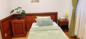 Un dormitorio con una cama con cabecero de madera. en Pensiunea Terra Serenity, en Snagov 3 fotos más