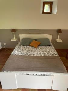 ein weißes Bett mit zwei Kissen darauf im Schlafzimmer in der Unterkunft Charmant gîte à la campagne ! Avec 2 SDB in Boismé