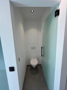 uma casa de banho com WC num quarto branco em Luxurious apartment with feet in the sea & city em Ostend mais 3 fotografias