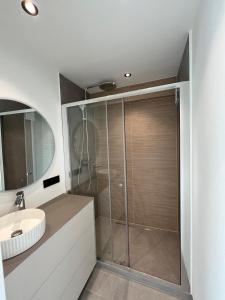 um banheiro com chuveiro e pia em Luxurious apartment with feet in the sea & city em Ostend