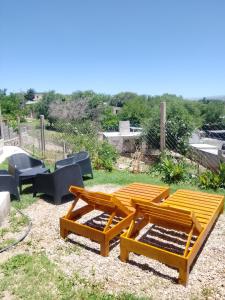 a group of picnic tables and chairs in a yard at ENCANTO SERRANO in Villa Carlos Paz