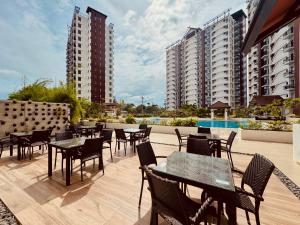 an outdoor patio with tables and chairs and buildings at YukiDo Skynest in Mactan Island