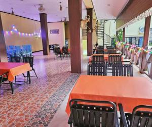 a dining room with tables and chairs and blue chairs at west water hostel in Vang Vieng