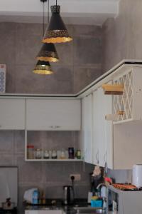 Una cocina con dos luces colgando del techo. en Muyenga Tank Hill Apartments, en Kampala