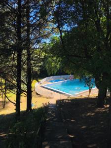 a large swimming pool in a park with trees at Hotel ALTOS DE ARUNA in Bialet Massé