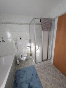 a bathroom with a shower and a toilet and a tub at Ferienwohnung mit Garten in der Nähe Landshut in Geisenhausen