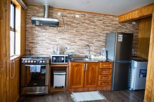 eine Küche mit einem Kühlschrank aus Edelstahl und einer Spüle in der Unterkunft Cabañas Sierra Dorotea in Puerto Natales