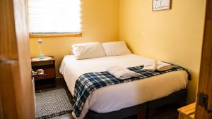 ein Schlafzimmer mit einem Bett, auf dem zwei Handtücher liegen in der Unterkunft Cabañas Sierra Dorotea in Puerto Natales