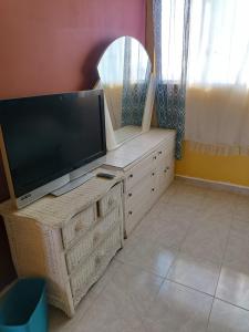 uma televisão de ecrã plano numa cómoda com um espelho em Hospedaje Barato Mi Casita de Colores em Tijuana