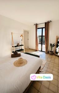 Villa Oasis Marrakech في مراكش: غرفة نوم مع سرير مع قبعة عليه