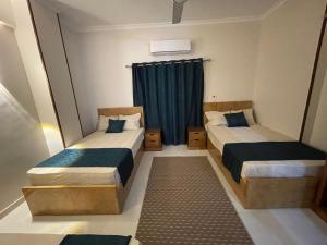 two beds in a small room with a window at Luxe Nest Guest House Apartment 21 in Luxor +31 photos