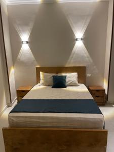 a bedroom with a bed with two lights above it at Luxe Nest Guest House Apartment 21 in Luxor