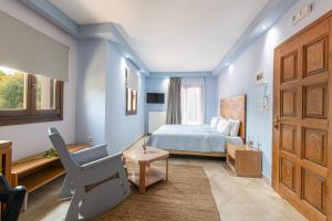 a bedroom with blue walls and a bed and a chair at Archodiko Toliadi Boutique Apartments and Suites in Ouranoupoli