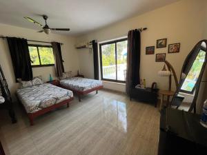 Indigo Orchid Homestay - A spacious, serene villa with terrace and farm view في Saligao: غرفة معيشة مع سرير ونافذة