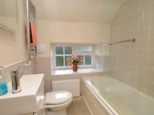 een badkamer met een bad, een toilet en een wastafel bij 3 Bed in Bridport oc-dc059 in Loders +50 foto's