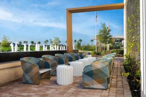 a row of chairs and tables on a patio at Hilton Garden Inn Orlando I-4 Millenia Blvd Mall in Orlando