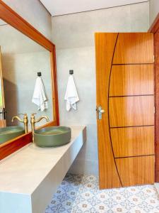 a bathroom with a green sink and a mirror at Hotel Pontal de Tiradentes in Tiradentes