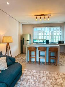 a kitchen with a kitchen island with stools and a refrigerator at Hotel Pontal de Tiradentes in Tiradentes