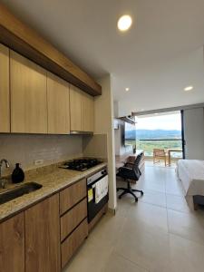 Cali Apartamento Pance 12-03 sector residencial exclusivo في Pance: مطبخ مع حوض ومكتب في الغرفة
