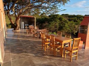 una fila de mesas y sillas de madera en un patio en pousada tucano, en São José da Barra