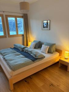 a large bed in a room with two windows at Ustreia Orta in Lohn