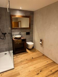a bathroom with a sink and a toilet and a mirror at Ustreia Orta in Lohn +62 photos