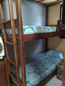 a bunk bed with a blue and white comforter at Casa Temporada Caraguatatuba in Caraguatatuba +2 photos