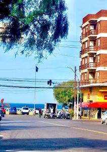 una strada con auto parcheggiate sul lato di un edificio di La Hélice a Puerto Madryn