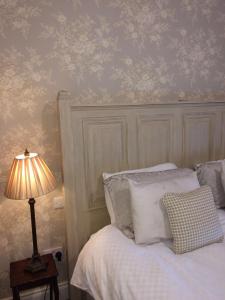 a bedroom with a bed and a lamp on a table at Riverbank, Country Pub and Guesthouse in Carrickmacross