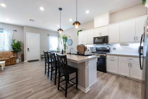a kitchen with white cabinets and a table with chairs at Chula Vista 3BR with Children's Playroom, Pool, Park and Sleeps 9 in Chula Vista