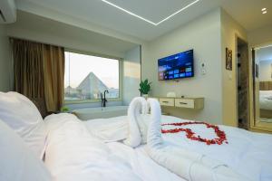 a bedroom with a white bed with a red flower on it at First Site OF Pyramids View & Jacuzzi in Cairo