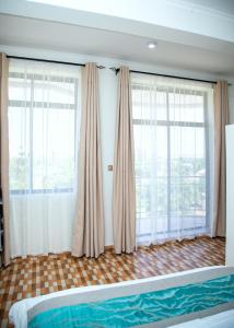 多多马JMG Homes的一间卧室设有2个大窗户和1张床