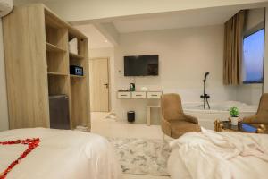 a bedroom with a bed and a tv and a tub at First Site OF Pyramids View & Jacuzzi in Cairo