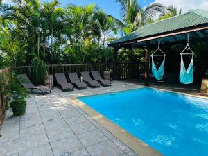 a swimming pool with lounge chairs and a gazebo at Titalee Lodge 3 Villas autour d'une piscine in Saint-François