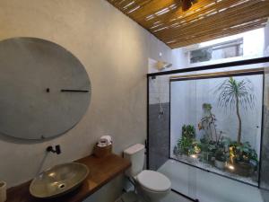 a bathroom with a sink and a toilet and a window at Casa mangarito - suítes in Ubatuba +291 photos