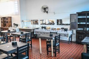 a restaurant with tables and chairs in a kitchen at Hotel Bandeirantes de SJBV in São João da Boa Vista