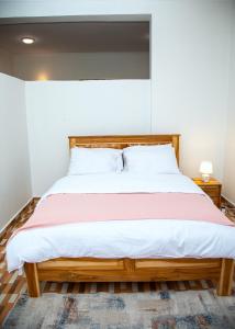 多多马JMG Homes的卧室里有一张带木质床头板的大床